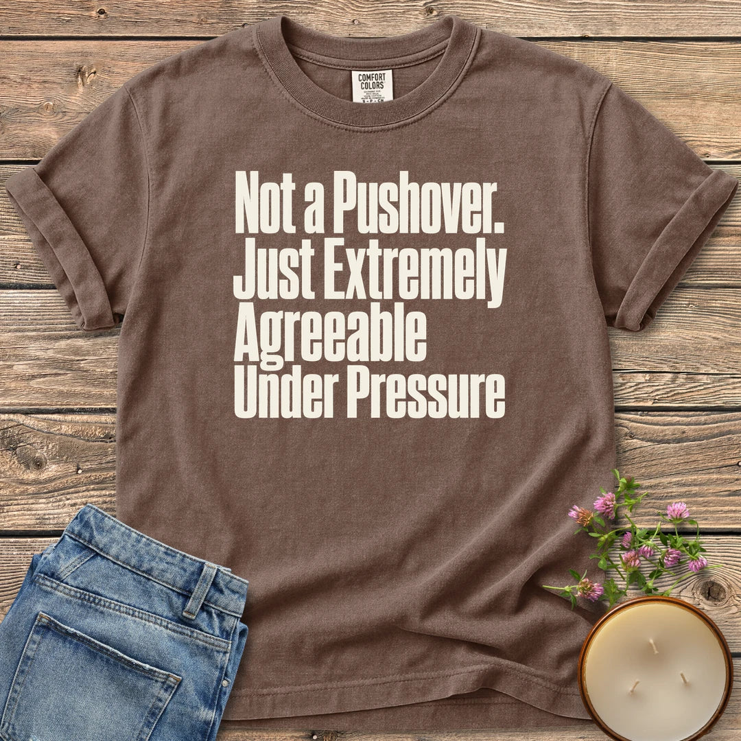 Not a Pushover t-shirt, Not a Pushover. Just Extremely Agreeable Under Pressure in bold condensed type, on an Espresso Comfort Colors tee