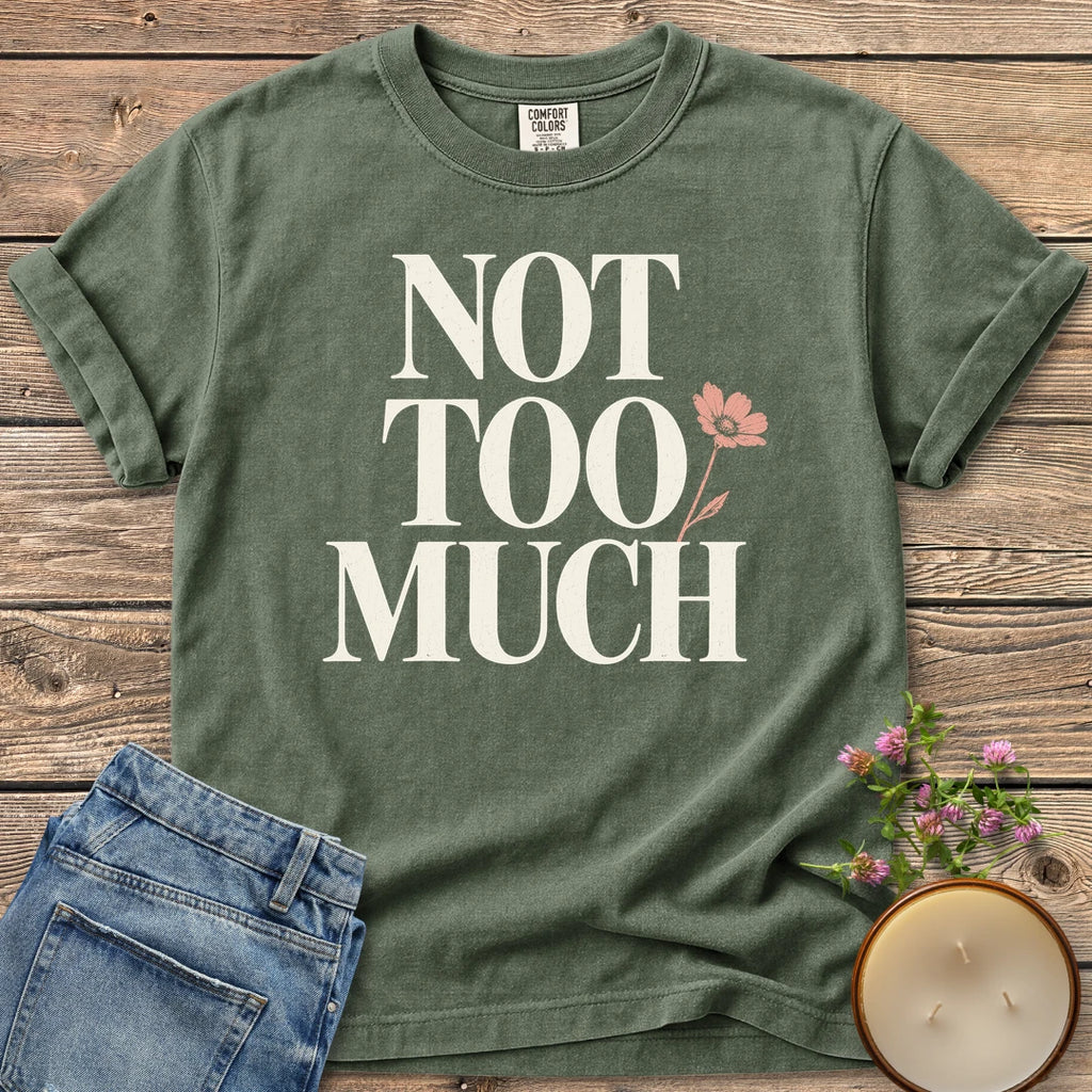 Not Too Much t-shirt, Not Too Much in tall serif letters with a pink flower, on a Moss Comfort Colors tee