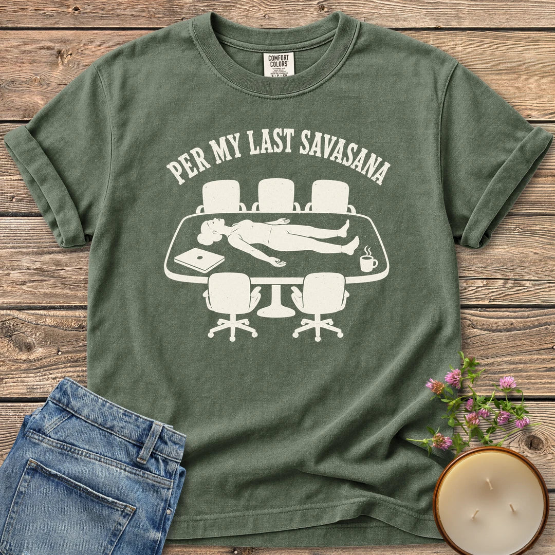 Per My Last Savasana t-shirt, a person lying flat on a conference table under Per My Last Savasana, on a Moss Comfort Colors tee