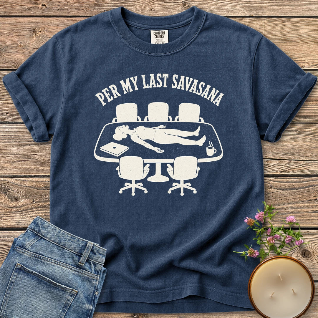 Per My Last Savasana t-shirt, a person lying flat on a conference table under Per My Last Savasana, on a Navy Comfort Colors tee