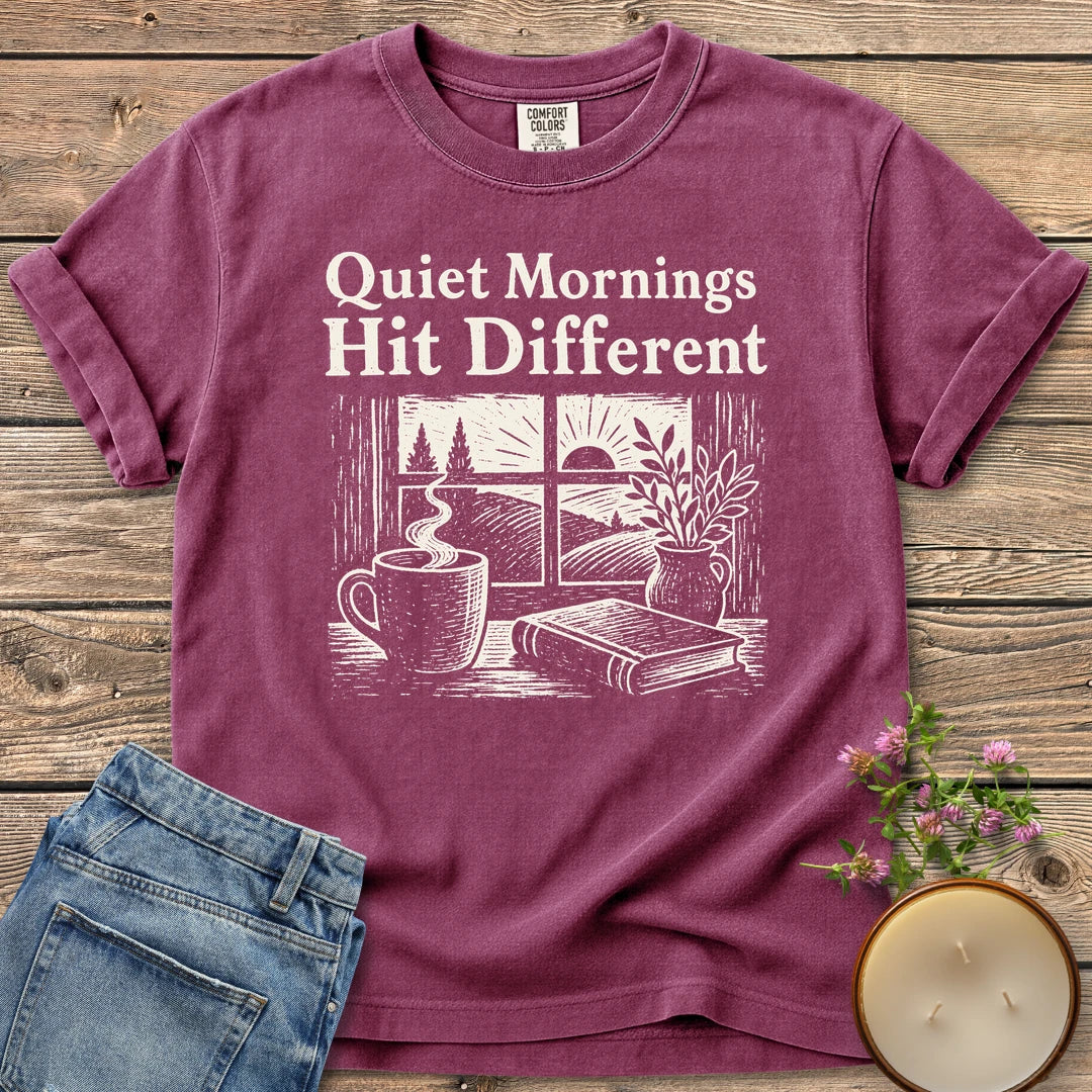 Quiet Mornings Hit Different t-shirt, Quiet Mornings Hit Different over a woodcut of coffee, a book and a window at sunrise, on a Berry Comfort Colors tee