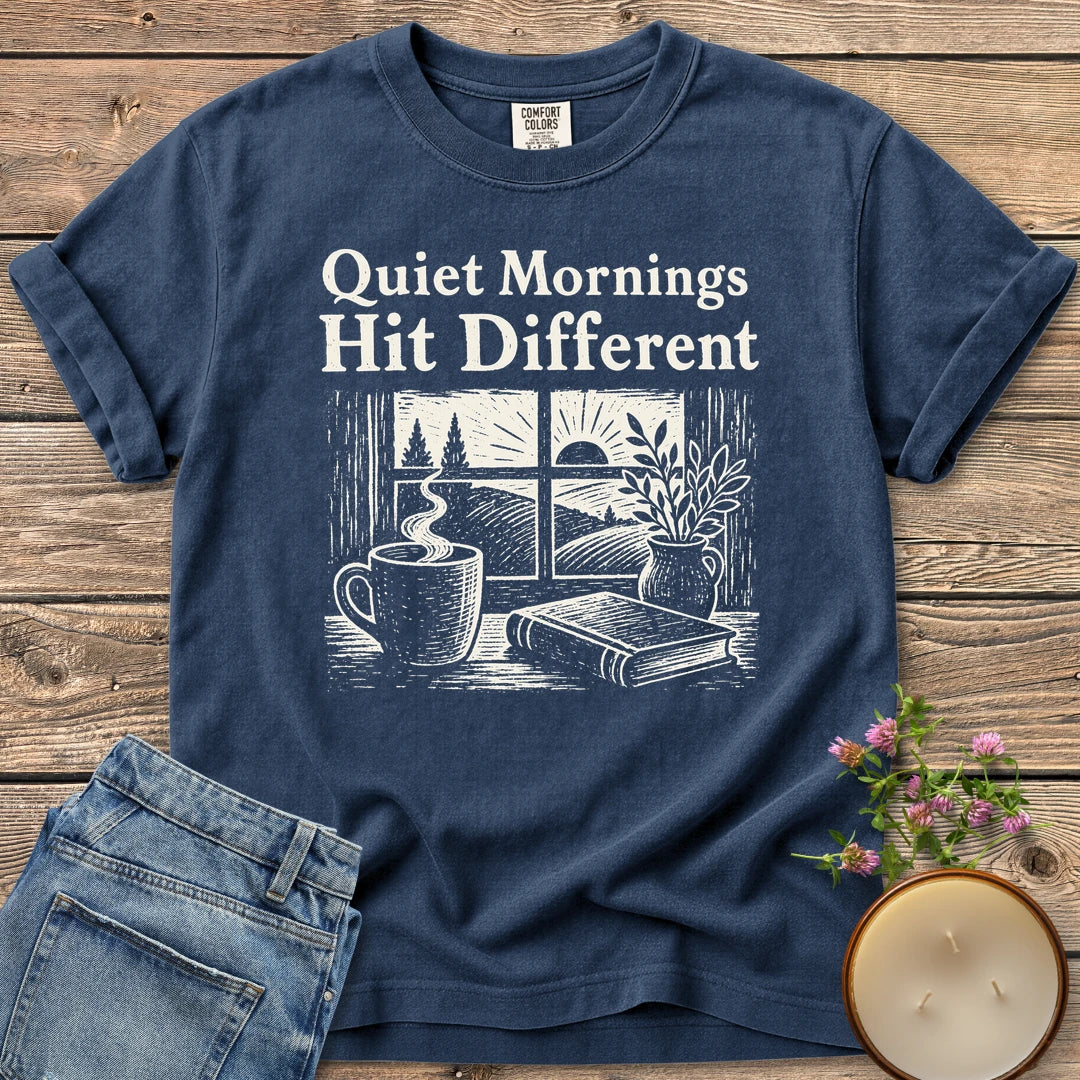 Quiet Mornings Hit Different t-shirt, Quiet Mornings Hit Different over a woodcut of coffee, a book and a window at sunrise, on a Navy Comfort Colors tee