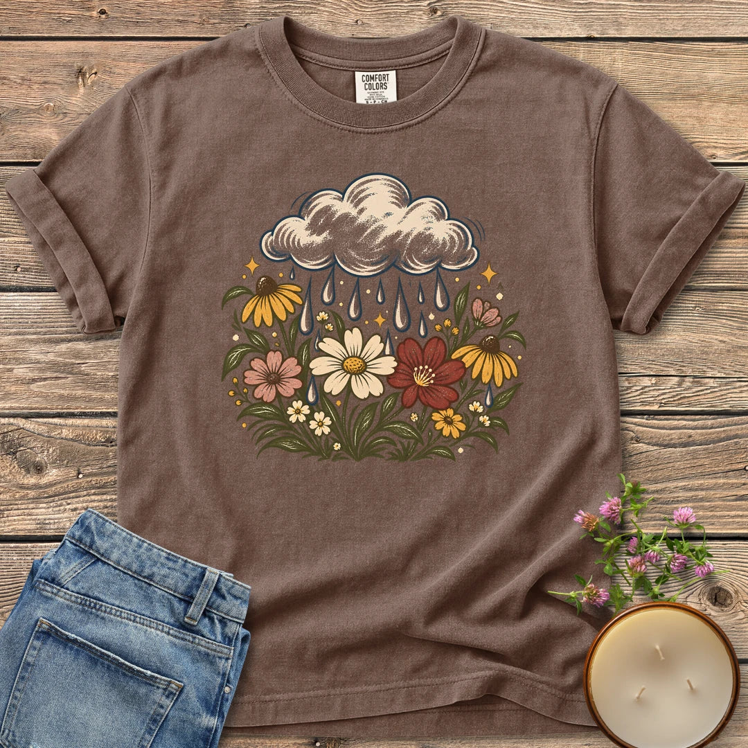Rain Cloud Wildflower Meadow t-shirt, a rain cloud watering a colorful wildflower meadow, on an Espresso Comfort Colors tee