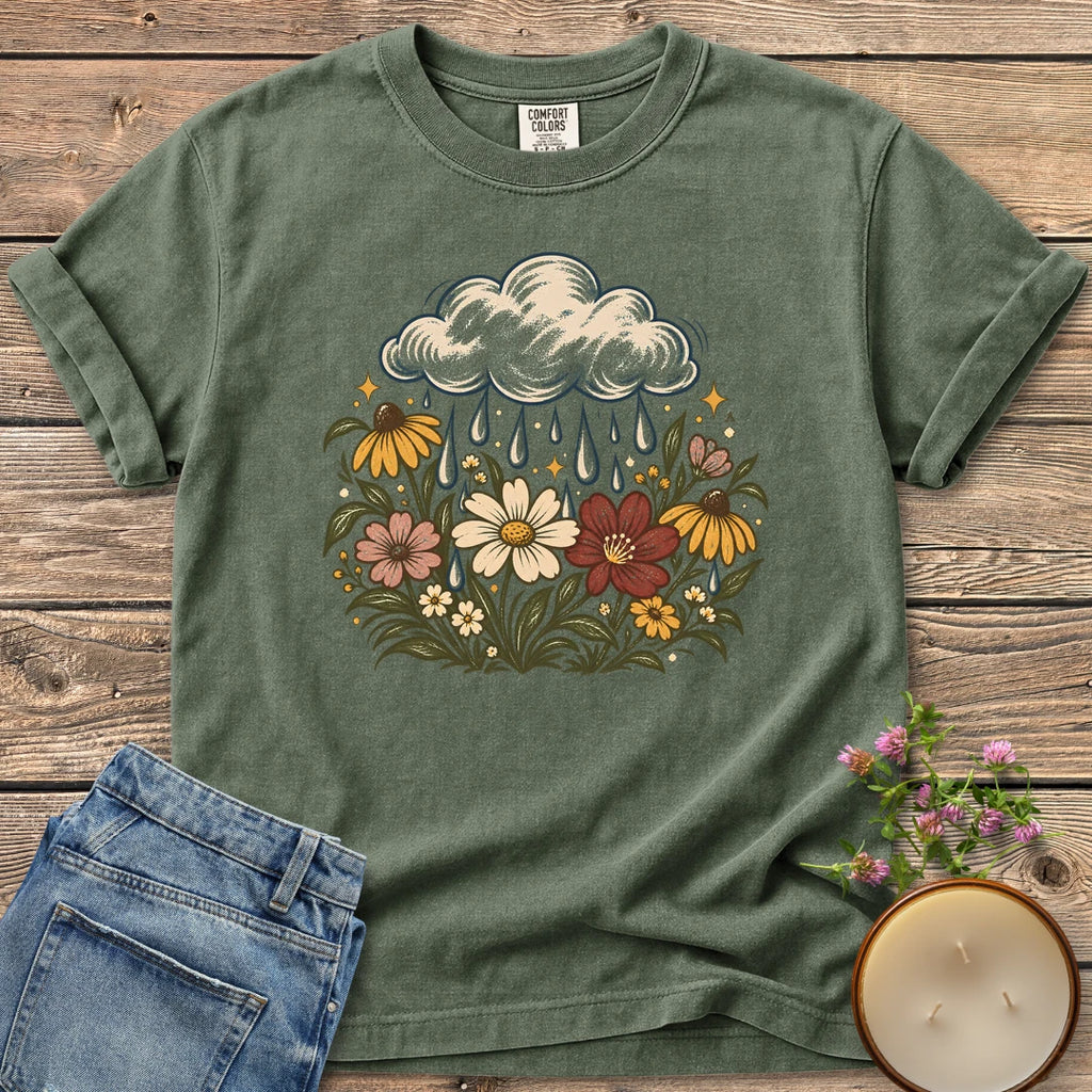 Rain Cloud Wildflower Meadow t-shirt, a rain cloud watering a colorful wildflower meadow, on a Moss Comfort Colors tee