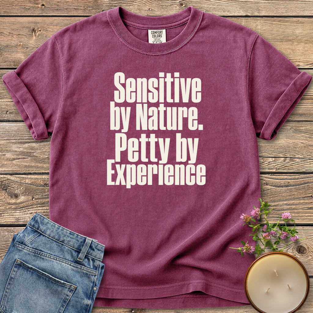 Sensitive by Nature t-shirt, Sensitive by Nature. Petty by Experience. in bold condensed type, on a Berry Comfort Colors tee