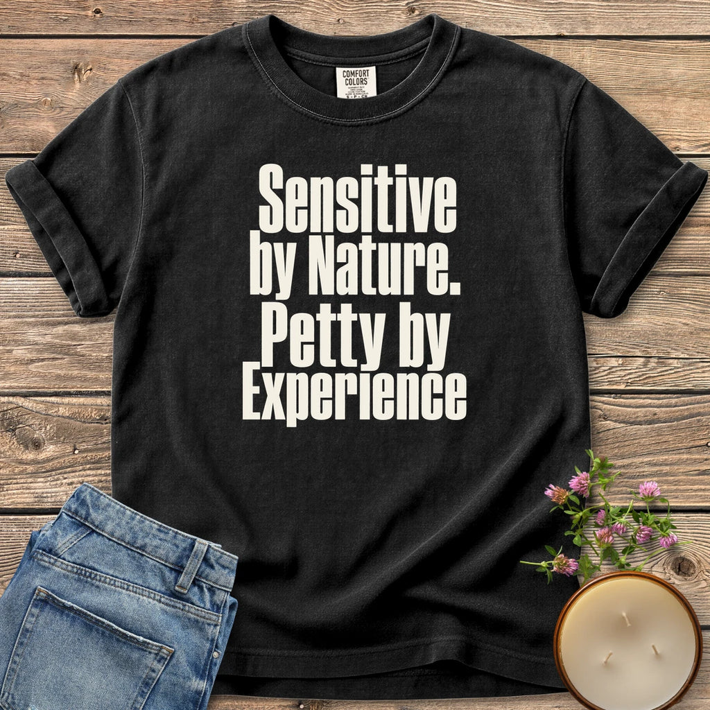 Sensitive by Nature t-shirt, Sensitive by Nature. Petty by Experience. in bold condensed type, on a Black Comfort Colors tee