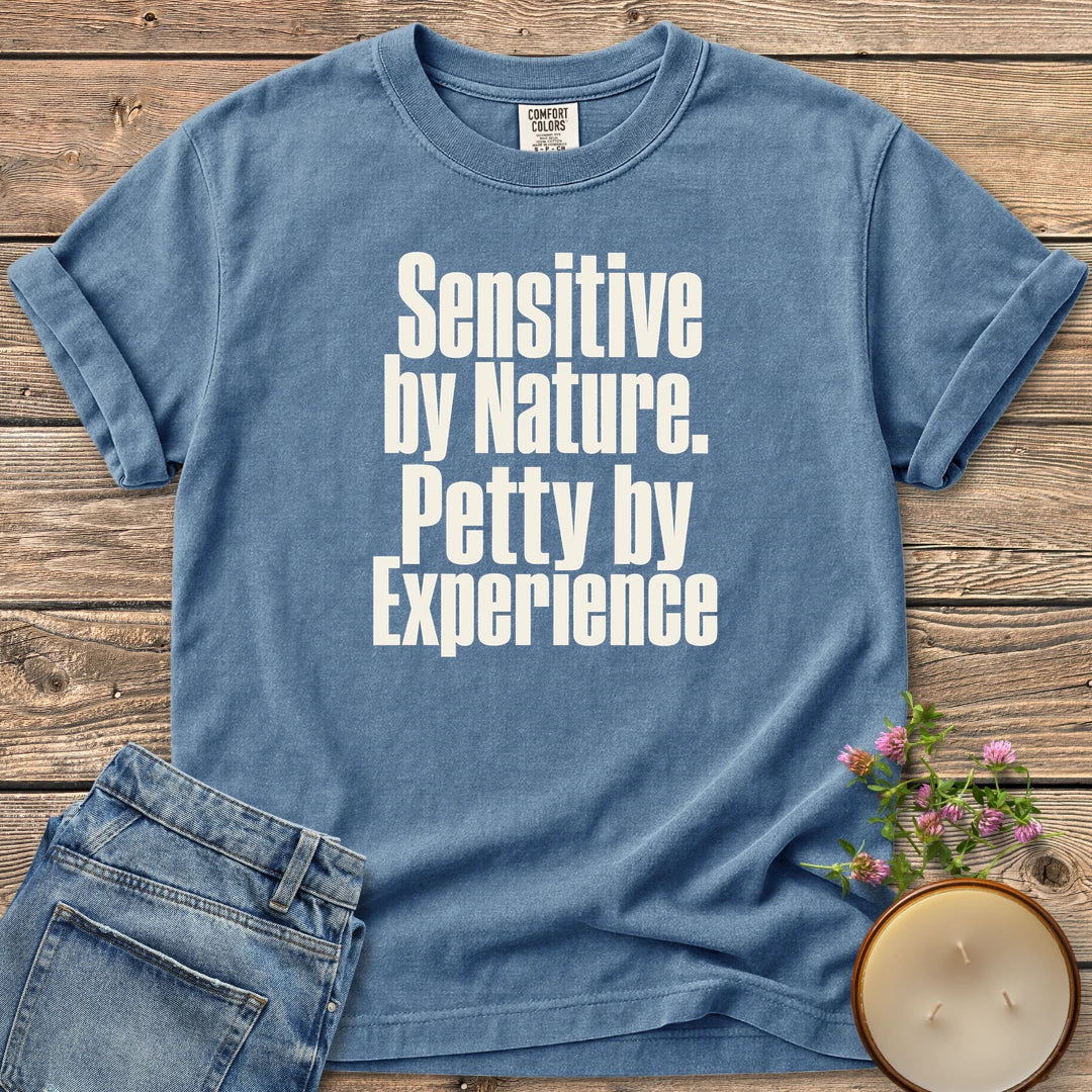 Sensitive by Nature t-shirt, Sensitive by Nature. Petty by Experience. in bold condensed type, on a Blue Jean Comfort Colors tee
