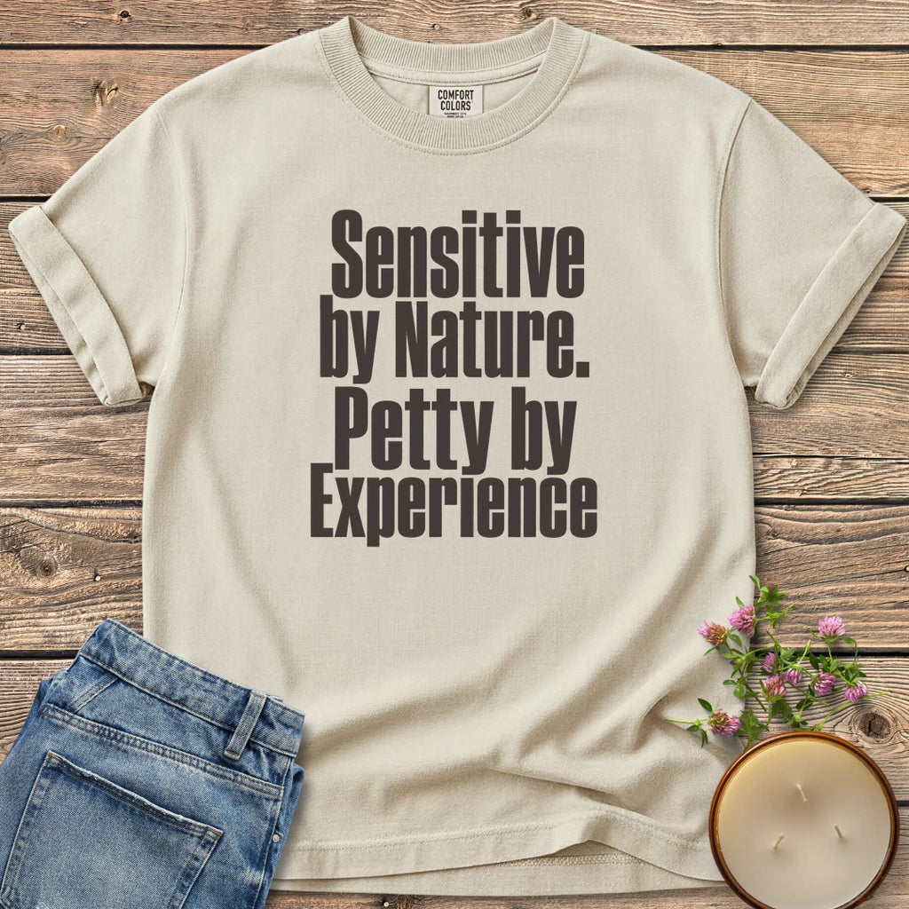 Sensitive by Nature t-shirt, Sensitive by Nature. Petty by Experience. in bold condensed type, on an Ivory Comfort Colors tee