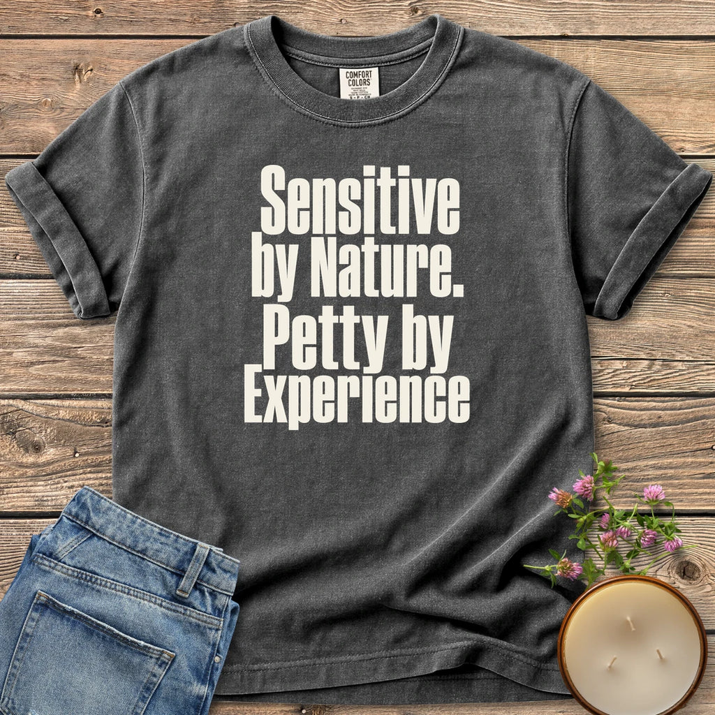 Sensitive by Nature t-shirt, Sensitive by Nature. Petty by Experience. in bold condensed type, on a Pepper Comfort Colors tee