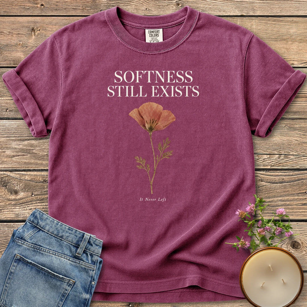 Softness Still Exists t-shirt, Softness Still Exists above a pressed poppy and It Never Left, on a Berry Comfort Colors tee