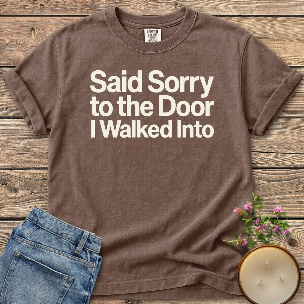 Sorry to the Door t-shirt, Said Sorry to the Door I Walked Into in bold sans type, on an Espresso Comfort Colors tee