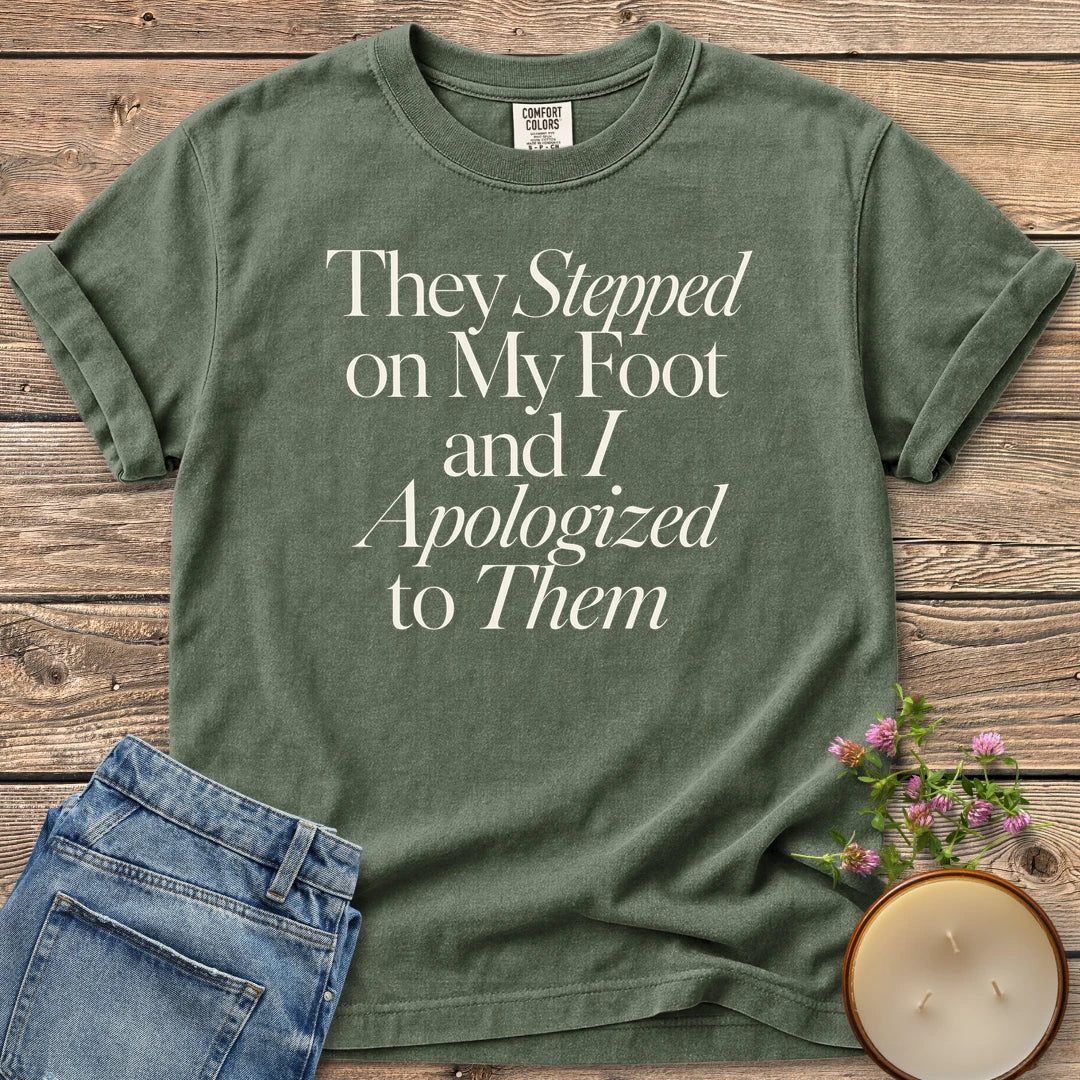 Stepped on My Foot t-shirt, They Stepped on My Foot and I Apologized to Them in serif and italic type, on a Moss Comfort Colors tee