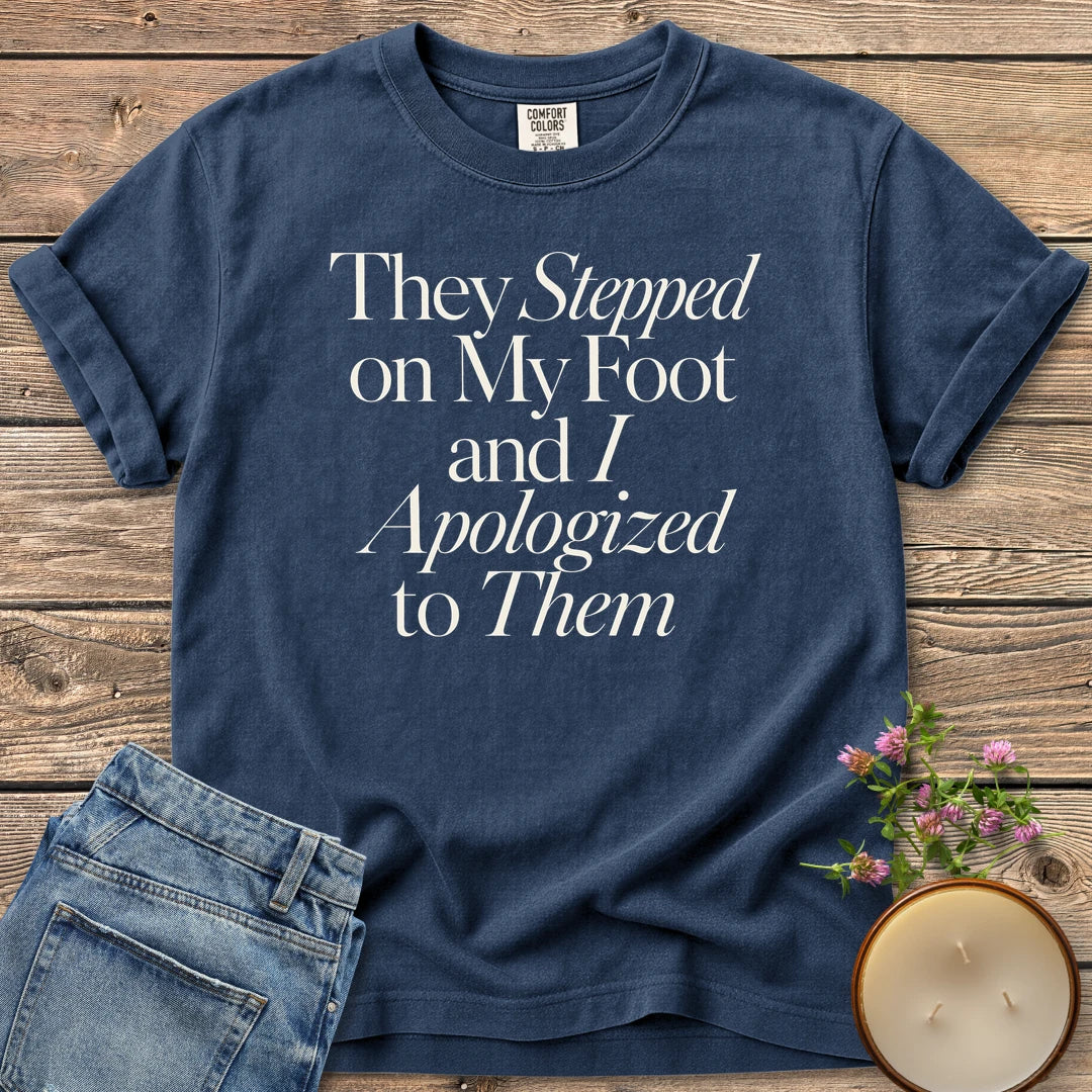 Stepped on My Foot t-shirt, They Stepped on My Foot and I Apologized to Them in serif and italic type, on a Navy Comfort Colors tee