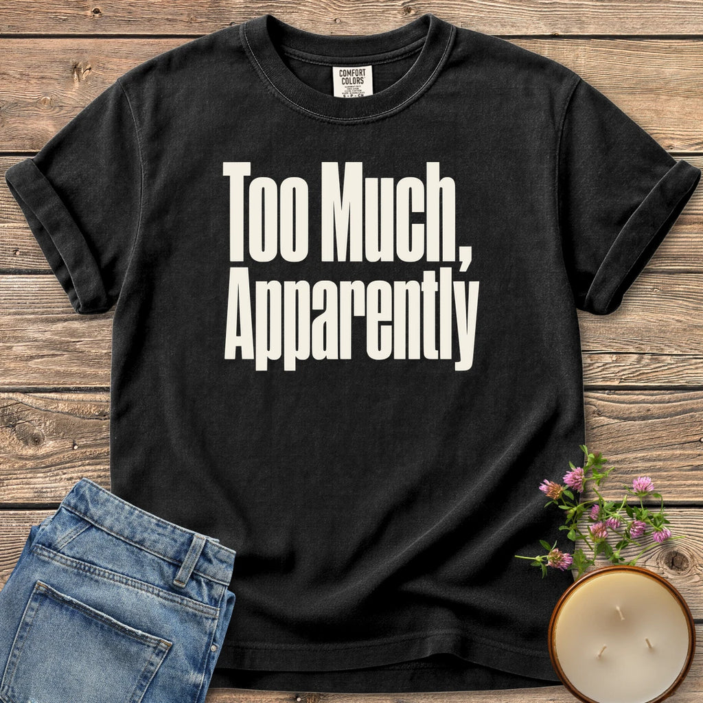 Too Much Apparently t-shirt, Too Much, Apparently in tall condensed type, on a Black Comfort Colors tee
