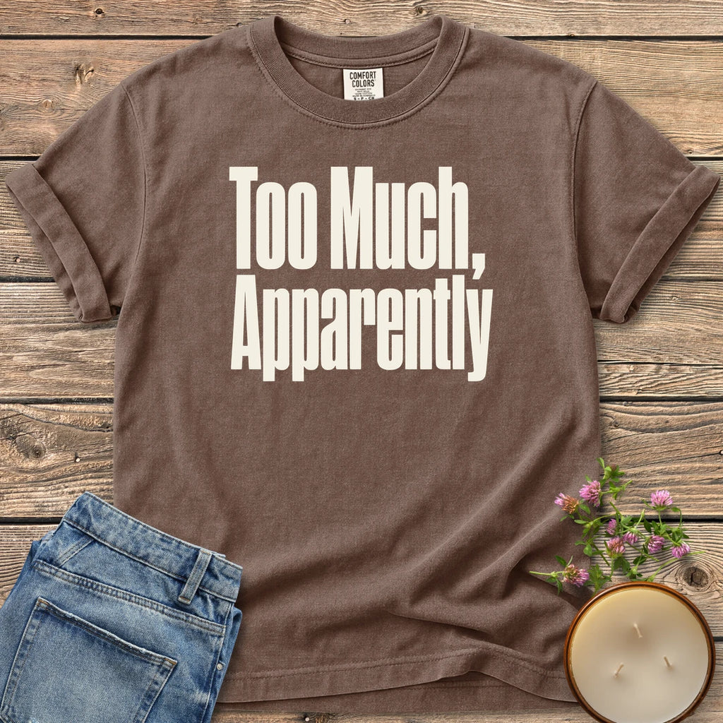 Too Much Apparently t-shirt, Too Much, Apparently in tall condensed type, on an Espresso Comfort Colors tee