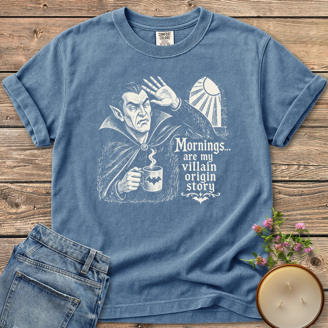 Villain Origin Story t-shirt, a vampire shielding his eyes from sunlight holding a coffee mug with Mornings... are my villain origin story, on a Blue Jean Comfort Colors tee