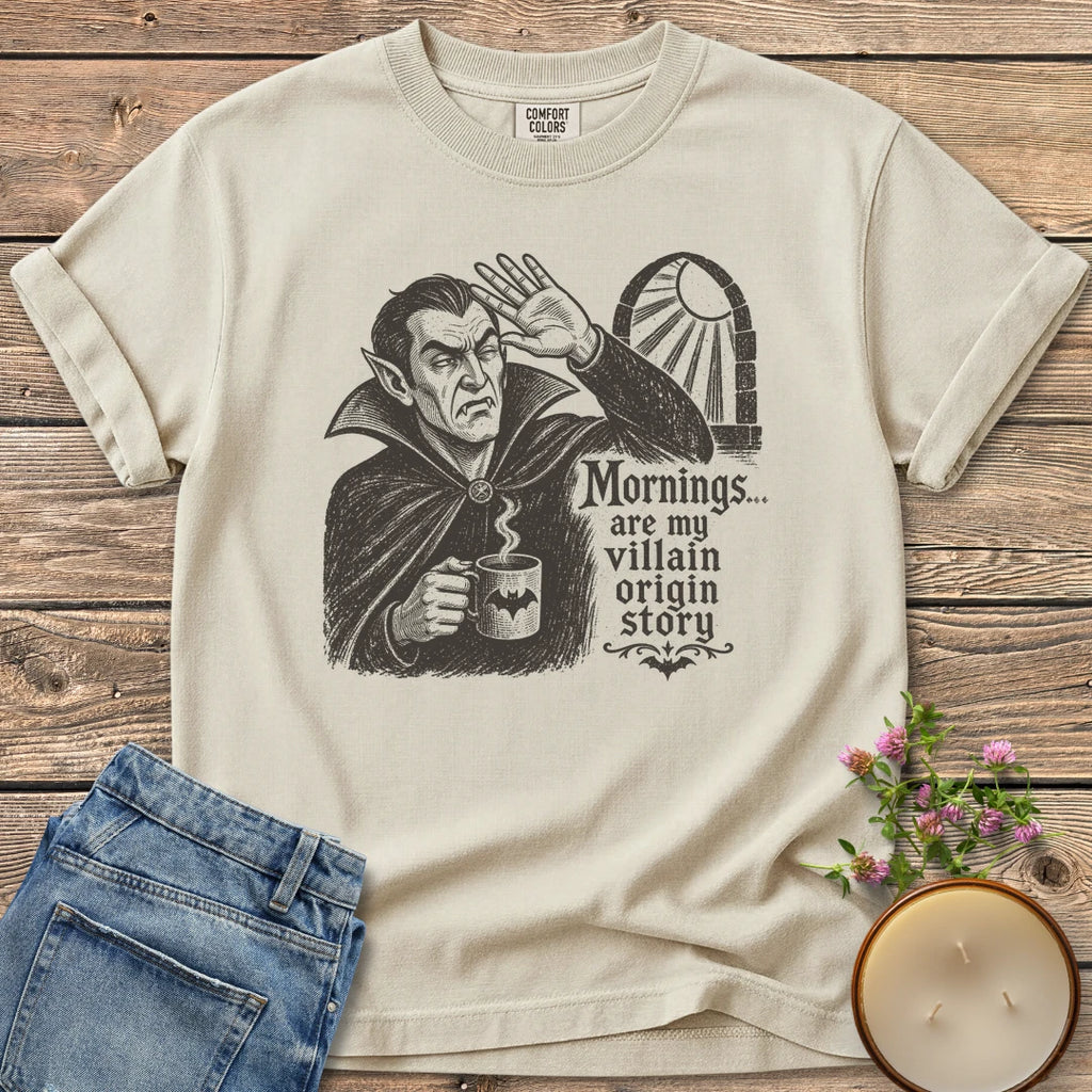 Villain Origin Story t-shirt, a vampire shielding his eyes from sunlight holding a coffee mug with Mornings... are my villain origin story, on an Ivory Comfort Colors tee