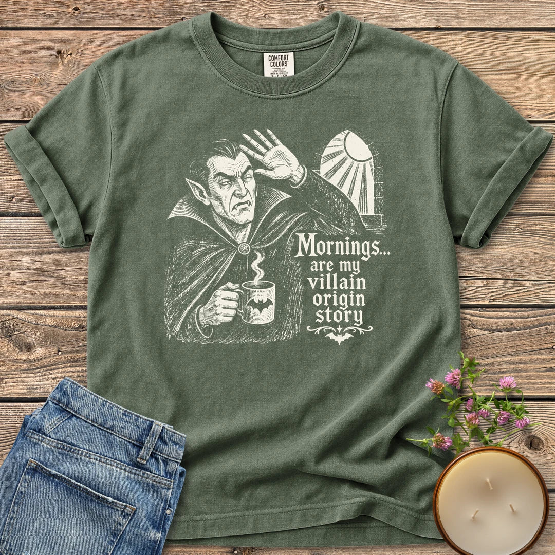Villain Origin Story t-shirt, a vampire shielding his eyes from sunlight holding a coffee mug with Mornings... are my villain origin story, on a Moss Comfort Colors tee