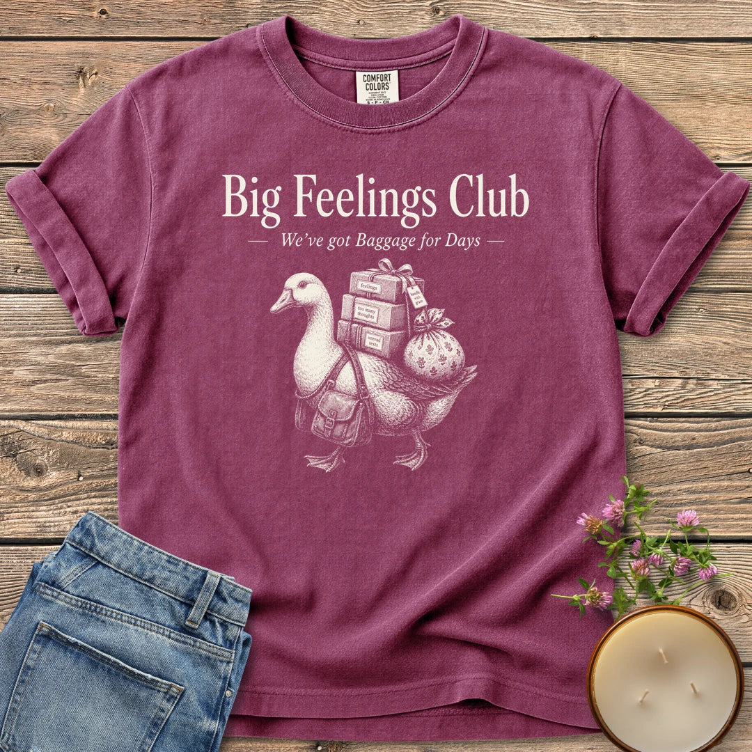 We've Got Baggage for Days t-shirt, a goose carrying boxes of feelings, too many thoughts and unread texts under Big Feelings Club, We've got Baggage for Days, on a Berry Comfort Colors tee