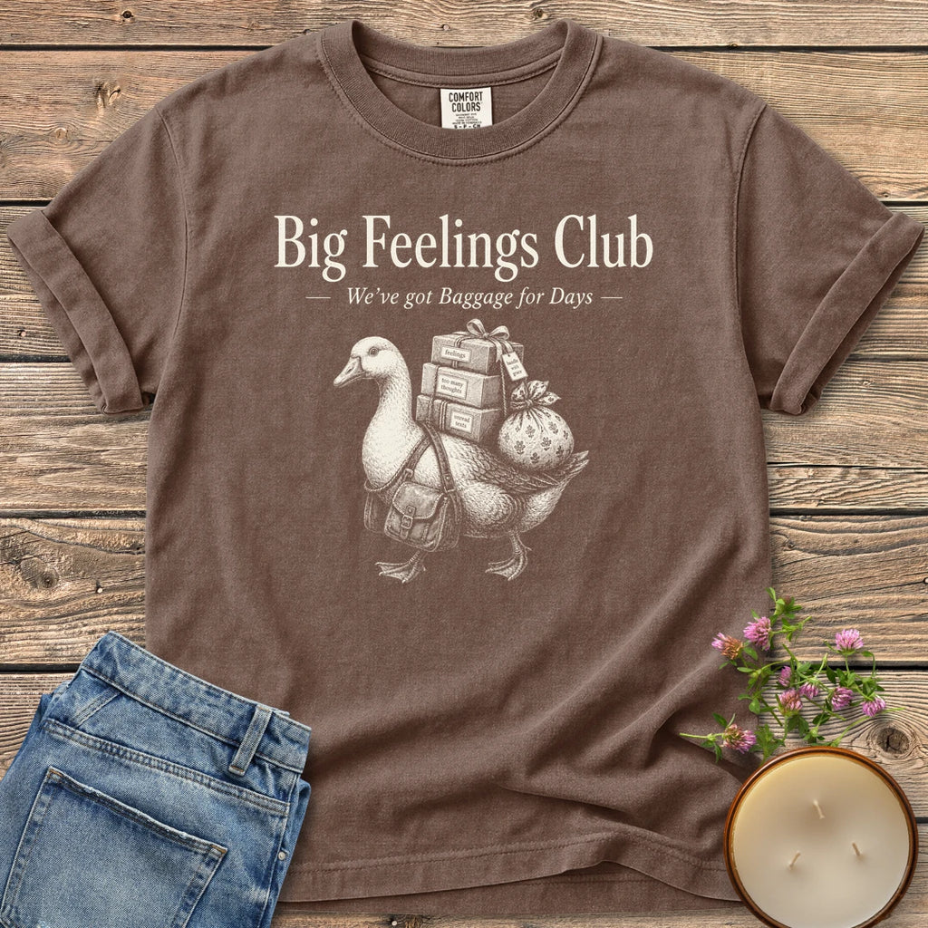 We've Got Baggage for Days t-shirt, a goose carrying boxes of feelings, too many thoughts and unread texts under Big Feelings Club, We've got Baggage for Days, on an Espresso Comfort Colors tee
