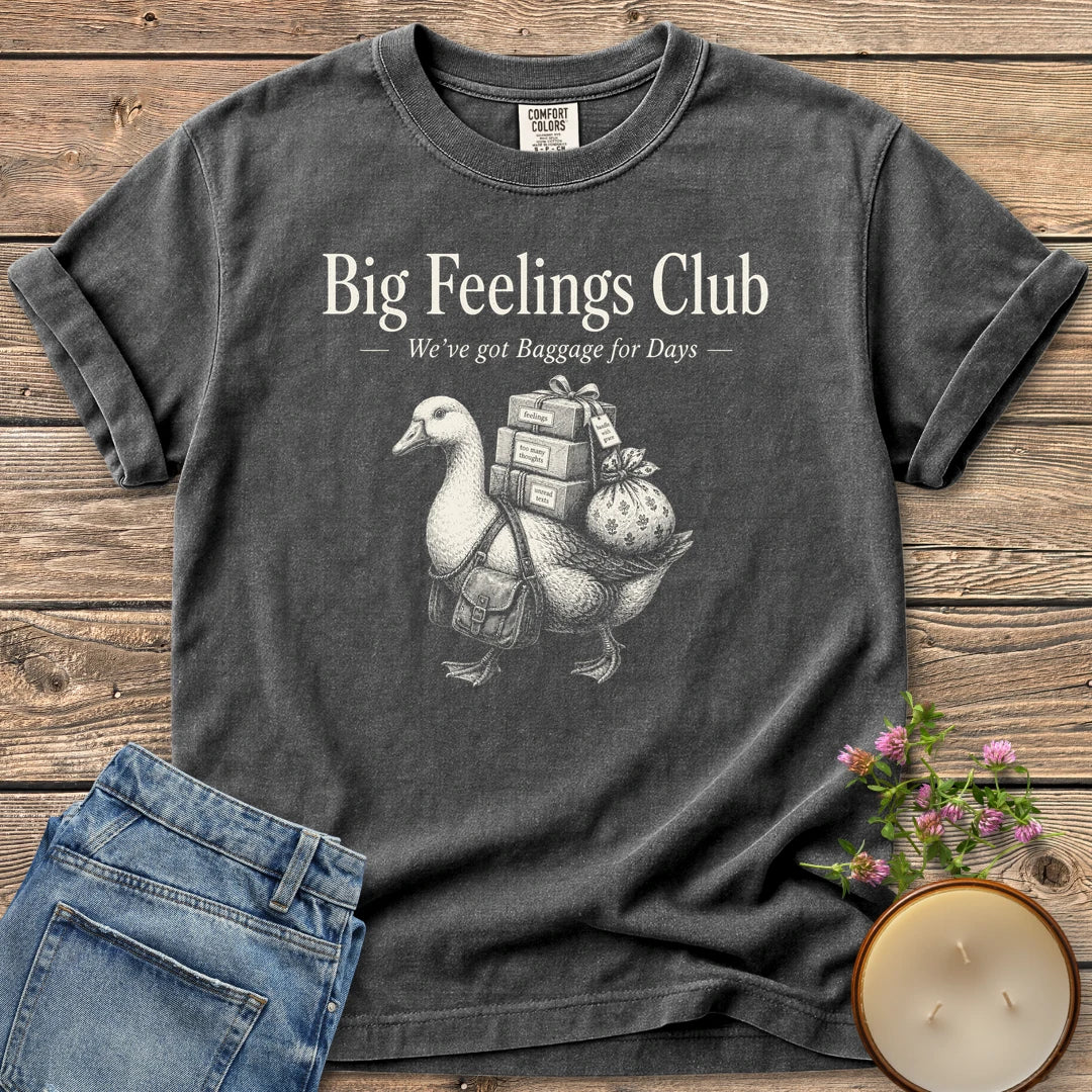 We've Got Baggage for Days t-shirt, a goose carrying boxes of feelings, too many thoughts and unread texts under Big Feelings Club, We've got Baggage for Days, on a Pepper Comfort Colors tee