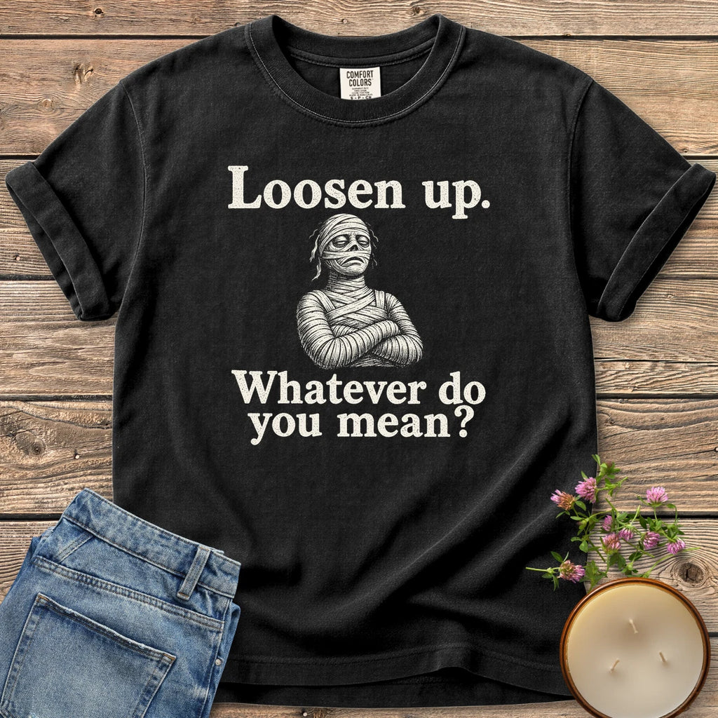 Whatever Do You Mean t-shirt, an annoyed mummy with crossed arms between Loosen up. and Whatever do you mean?, on a Black Comfort Colors tee